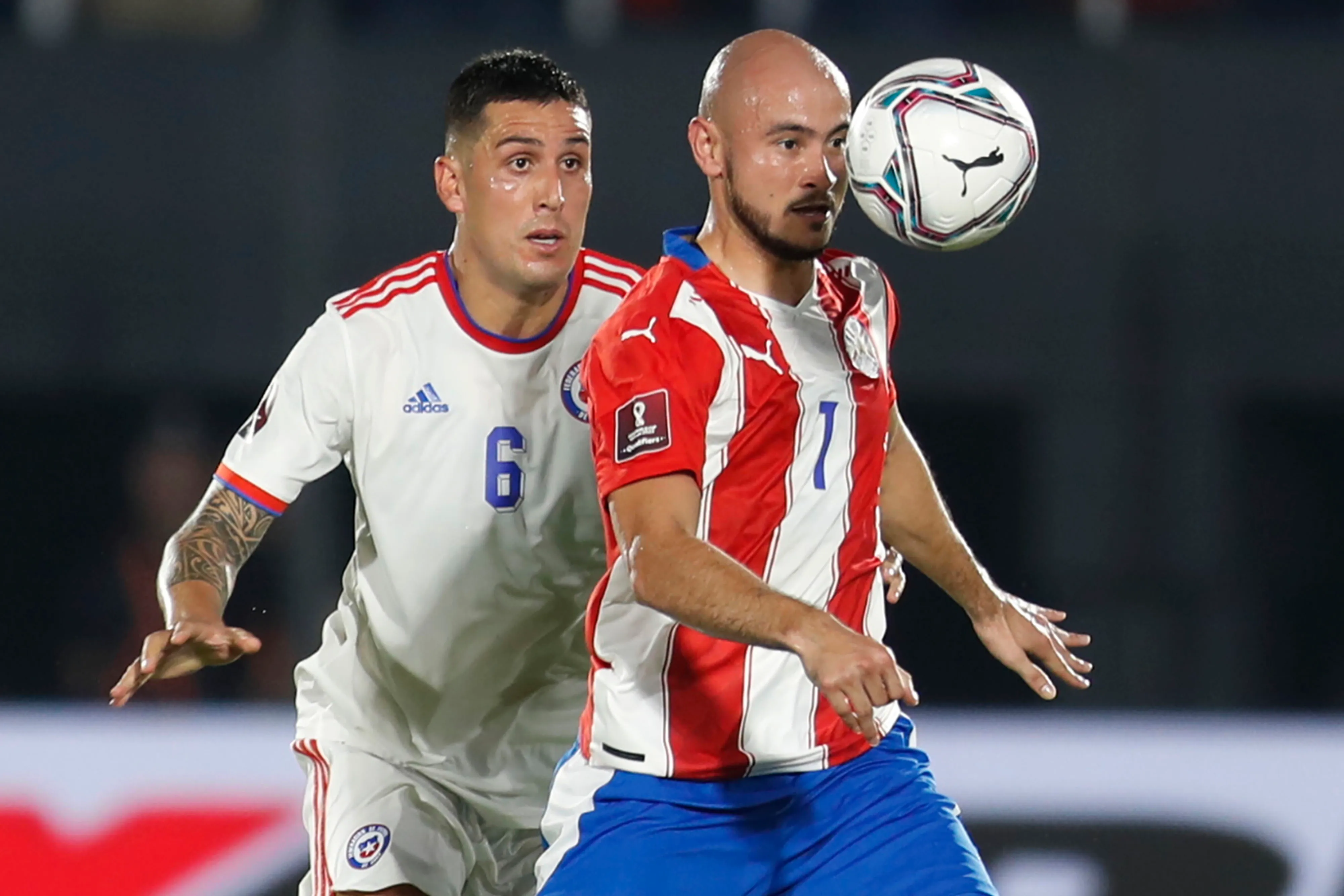 Carlos González aguanta la marca de Enzo Roco en un partido entre Chile y Paraguay. (Alejandra Gomez/Photosport).