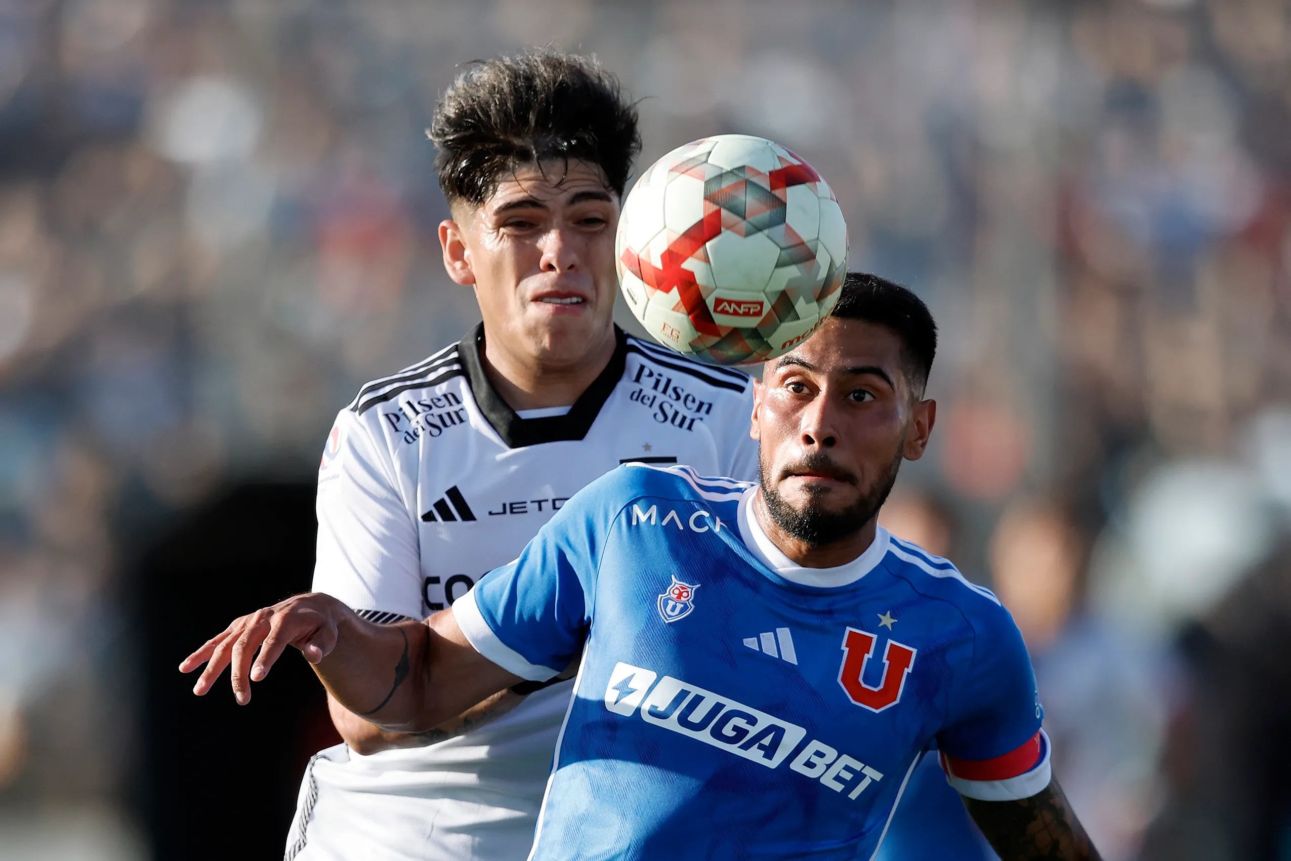 Carlos Palacios lucha con Emmanuel Ojeda en el Superclásico del fútbol chileno. (Pepe Alvujar/Photosport).